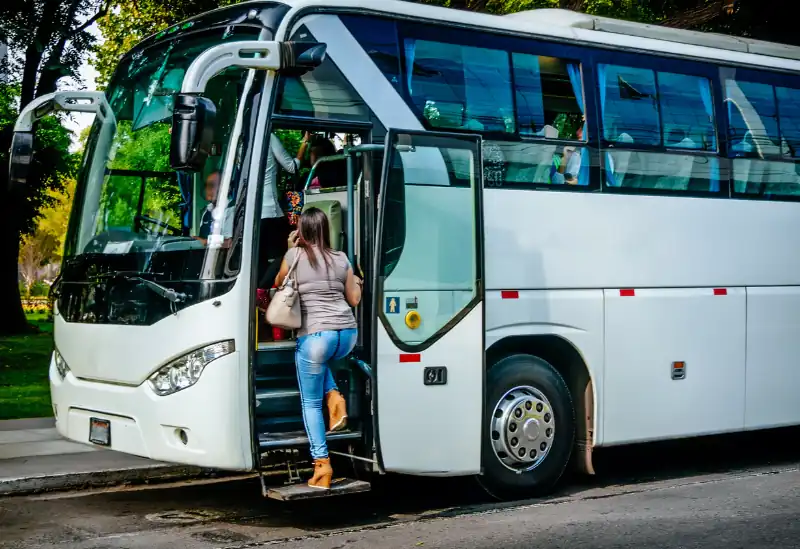 A woman getting on the stationary bus and starting their budget-friendly UK coach journey.
