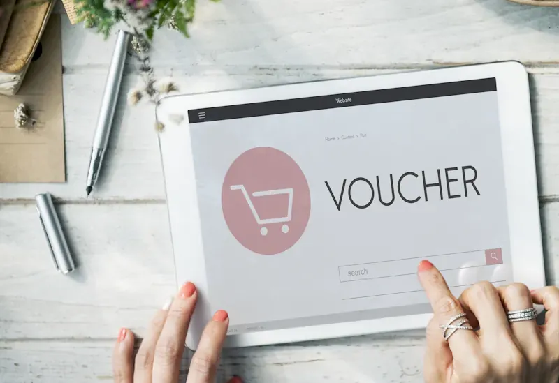 Discount codes fail at checkout. Frustrated customer stares at screen, puzzled. Unusable code lies discarded