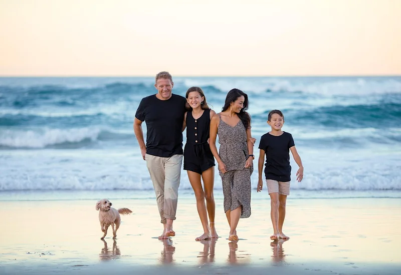 Family with two children and a dog enjoying a sunny day on the beach