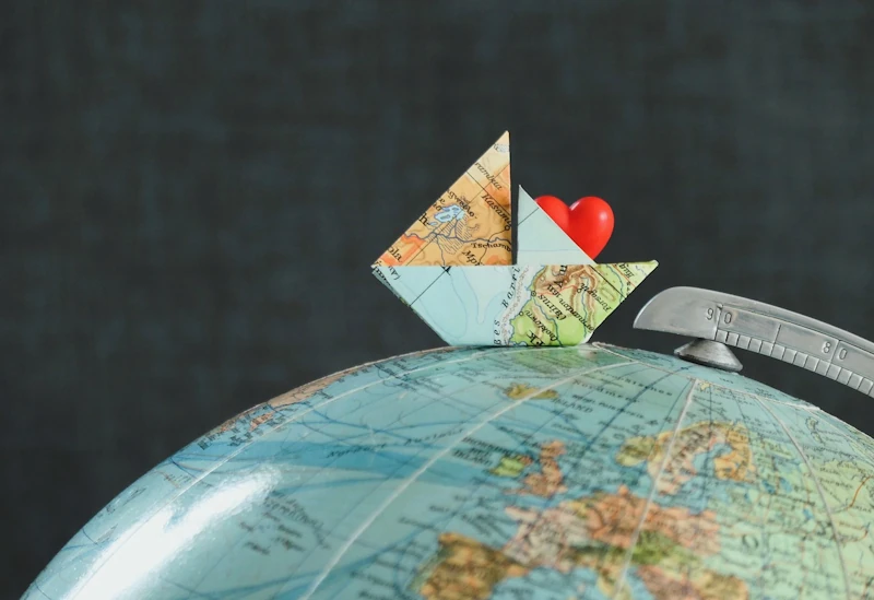 Travel-themed globe with a small boat made from a map.