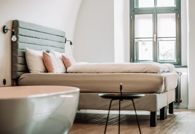 Hotel room with bed and bath used to illustrate hotel discount codes.