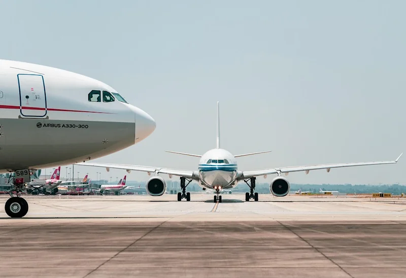 Two planes at an airport runway preparing for departure