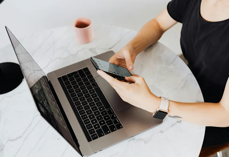 Woman using a smartphone and laptop while shopping online