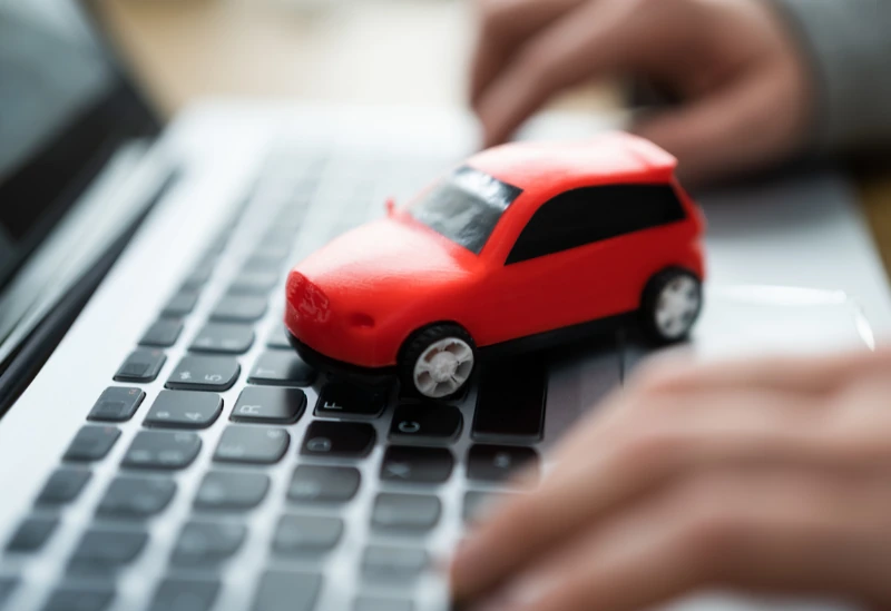A young person looking at car finance options on a laptop with a focus on affordability.