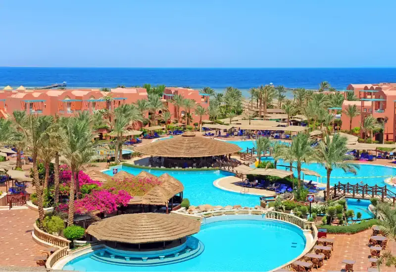 Hotel resort with pool and palm trees by the sea
