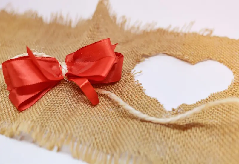 DIY budget-friendly gift ideas: heart-shaped fabric and red ribbon for creative Christmas presents