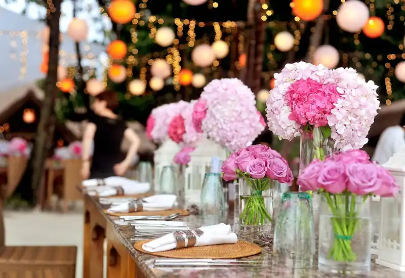 Wedding reception banquet table decorated with pink floral arrangements