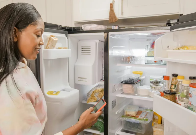 Person checking the contents of their fridge while deciding what food to use.