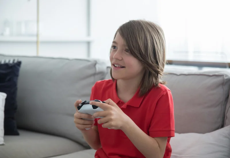 Young person playing video games at home next to the Savzz loot box and in-game spending calculator