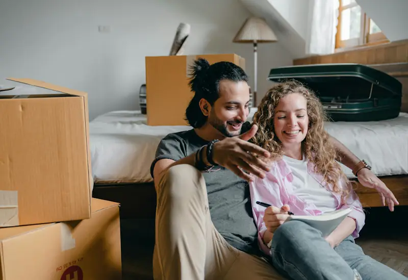 A couple planning housing costs while moving into a new home, representing rent affordability in the UK.
