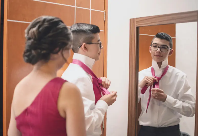 Person getting ready and adjusting a tie before attending a wedding.