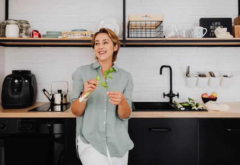 Air fryer on a kitchen counter in a modern kitchen while someone prepares food.
