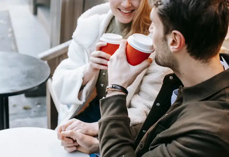 Two people having coffee together at an outdoor café.