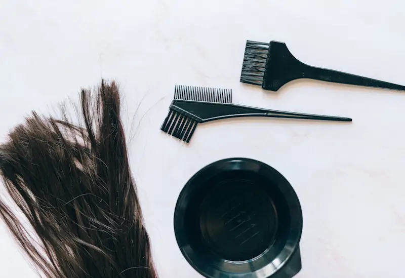 Hair dye and mixing tools on a bathroom counter for at-home colouring.