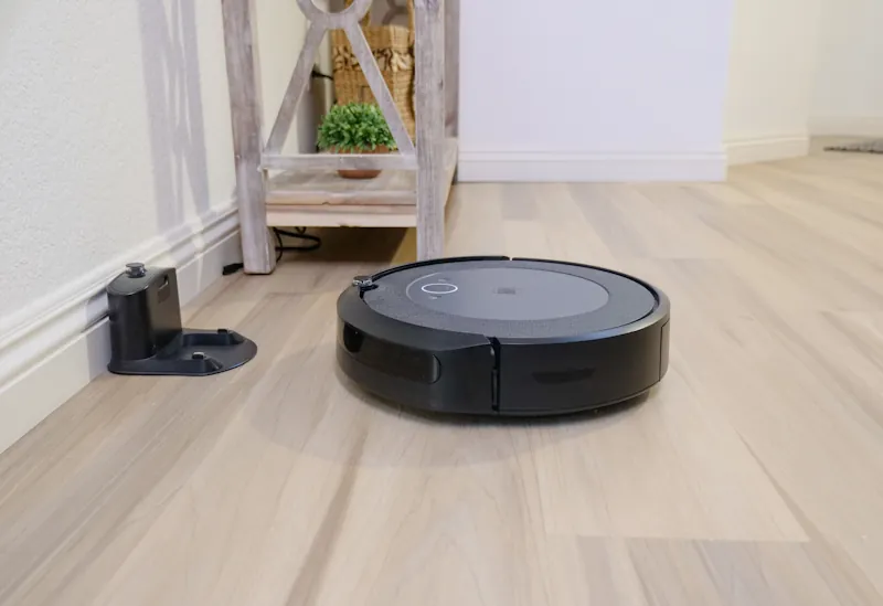 Robot vacuum next to its charging dock in a modern living room.