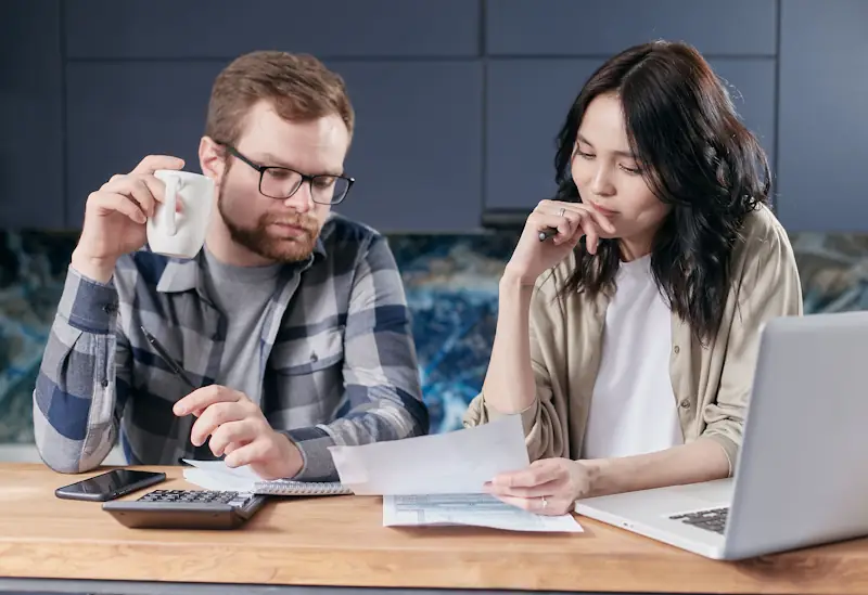 Two people calmly reviewing their finances at a table.
