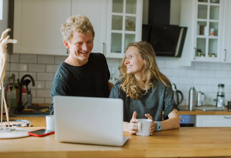 Two people reviewing daily spending habits at home, representing behavioural finance and everyday money decisions in the UK.