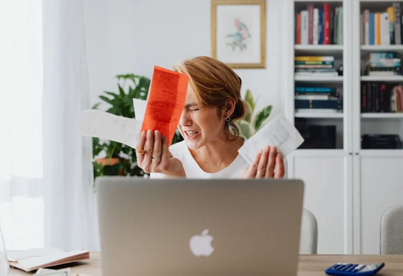 Person reviewing a pile of small receipts at a desk, illustrating how everyday spending quietly adds up over time.